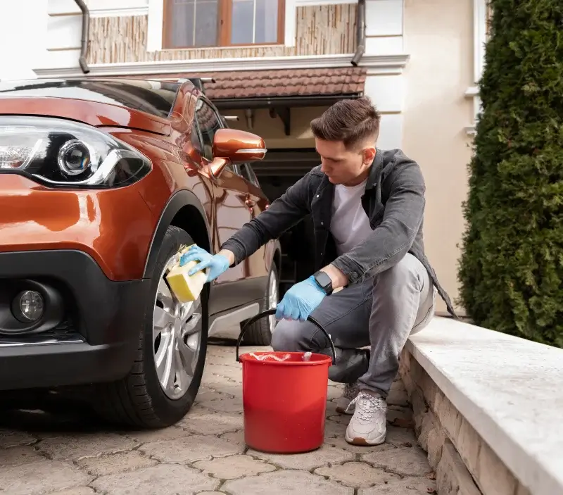 Lavage auto à domicile Peyrelevade : professionnel intervenant sur un véhicule